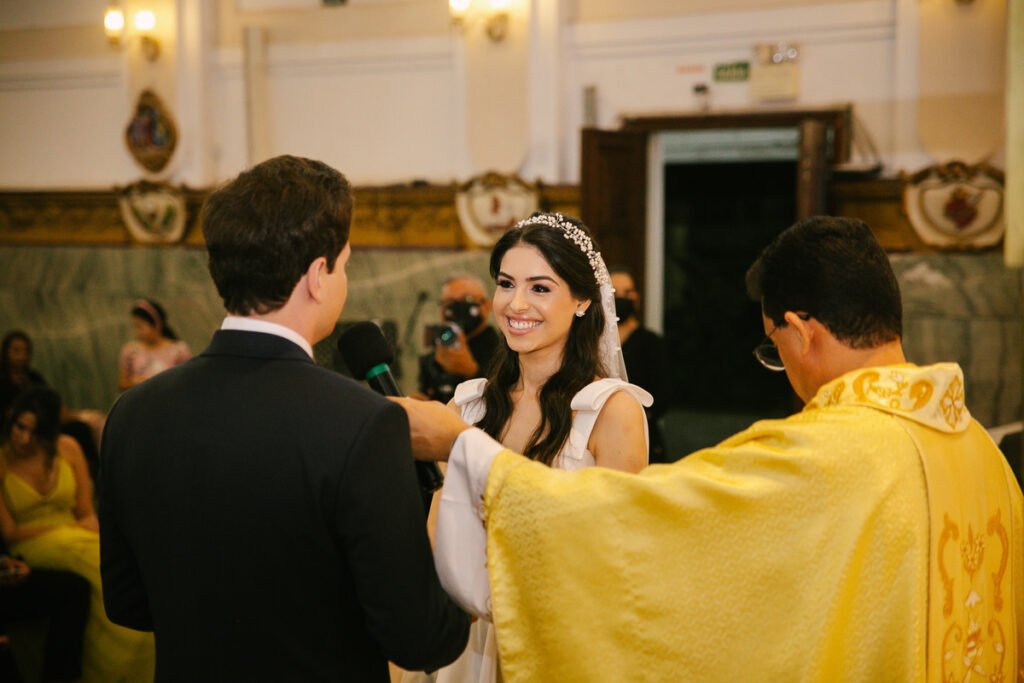 Noivos trocando votos durante a cerimônia de casamento diante do celebrante

