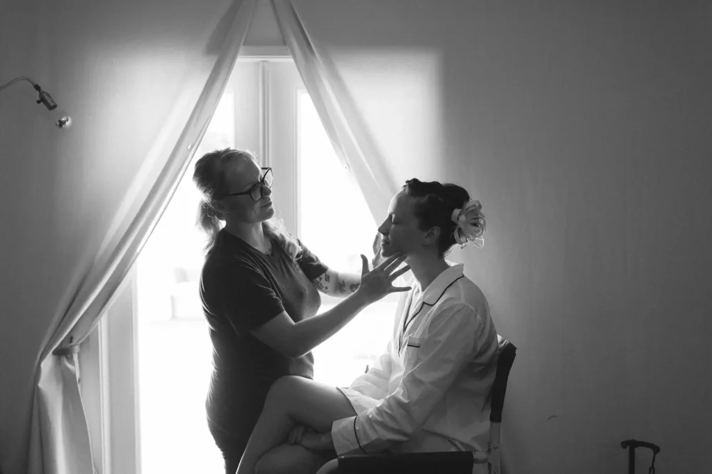 Profissional maquiando noiva durante os preparativos do casamento