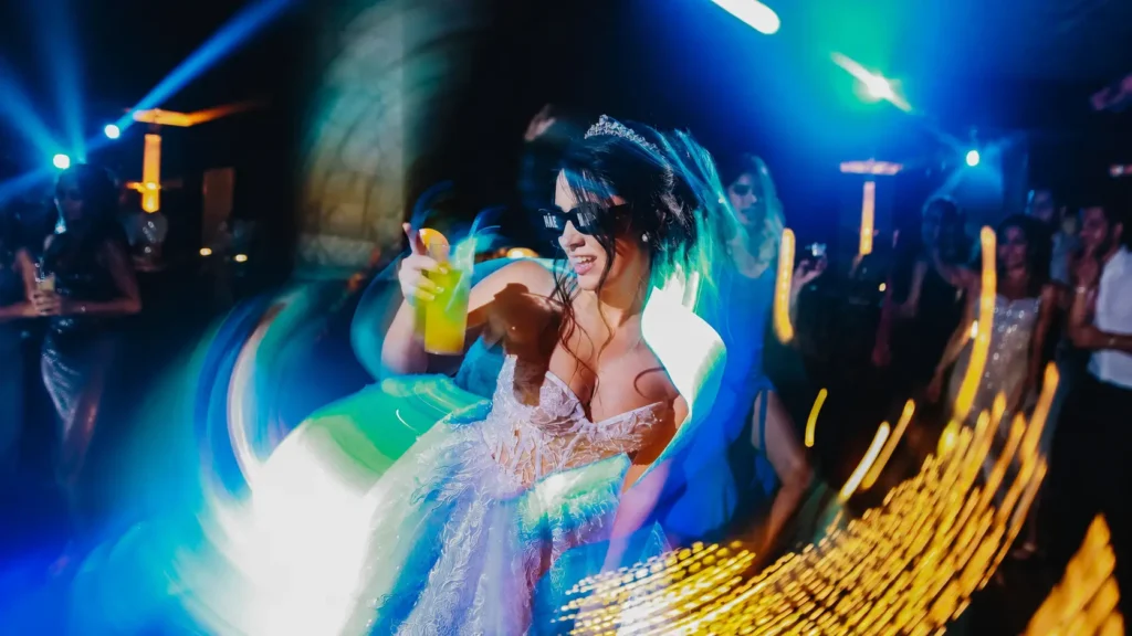 Noiva dançando na festa de casamento sob luzes coloridas